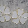 Textured floral painting of two white flowers with gold edges on gray