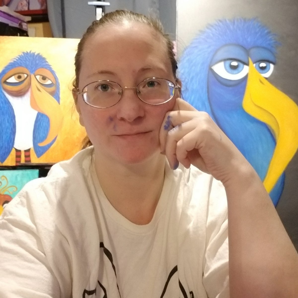 Kristy Lewellen in her studio with her whimsical bird paintings